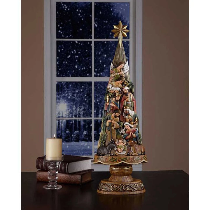Catholic Nativity Christmas tree centerpiece with carved religious figures for home or sanctuary display.