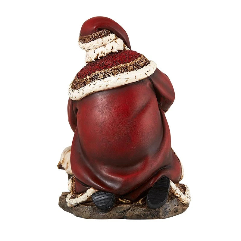 Religious Christmas figurine featuring Santa reverently adoring the Christ Child.